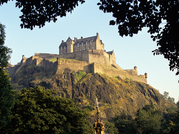 Edinburgh castle in summer surrounded by lush greenery