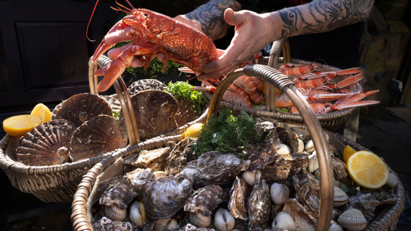 Chef at the Witchery carrying 2 baskets of food