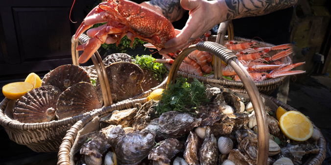 Chef at the Witchery carrying 2 baskets of food