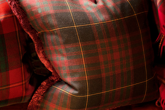Bespoke tartan cushion sat on a window seat in a luxurious suite